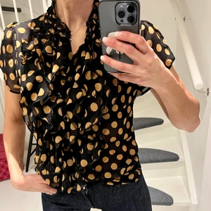 Saint Tropez blus - Klassiska blusen från Saint Tropez med härligt krås. Sitter så fint på! Underbart mönster, svart med gula prickar! Stlk S. Använd ett fåtal tillfällen!