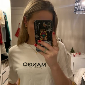 Mango T-shirt  - En mango T-shirt med broderat motiv i storlek xs. Tröjan är köpt i Spanien från en mangobutik och är i mycket fint skick! Skön vanlig T-shirt, något kroppad!🥭✨🤍