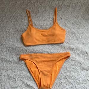 En neonorange bikini med både överdel och underdel. Bikinin är i storlek 36/S och man kan justera toppens band. 