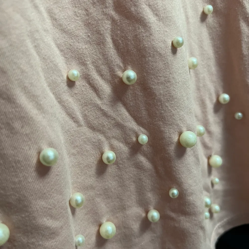 Croppad ljusrosa t-shirt med pärlor. Strl M men är enligt mig väldigt liten i storleken så skulle mer säga att den är XS/S . T-paidat.
