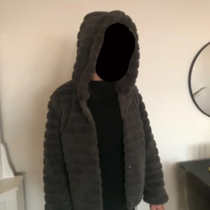 Fuskpäls - Grå fuskpäls jacka med stor skön luva. Tyvärr saknas 2 knappar
