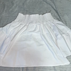 Off shoulder vit tröja - Off shoulder vi tröja med en roset bak på ryggen som du kan forma till själv, armarna är breda (som det visas i bilden) längden på ärmen kommer inte hela vägen ner.