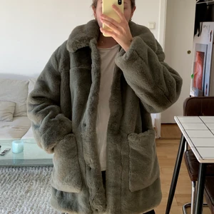 Jacka i fuskpäls  - Superfin mysig jacka i en härlig grön färg från H&M. Storlek 34 men passar även 36! Den köptes för ca två år sen men är knapp använd, därav är ”pälsen” forfarande i superbra skick och inga andra slitningar! Köparen står för frakten men har även möjlighet att mötas upp i Stockholm😁