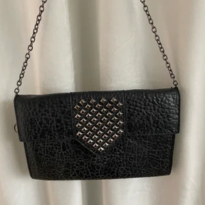 Väska med nitar - Svincool kuvertväska med nitar!! Bra skick och kedjan kan stoppas in (som på andra bilden) då den är väldigt lång👌