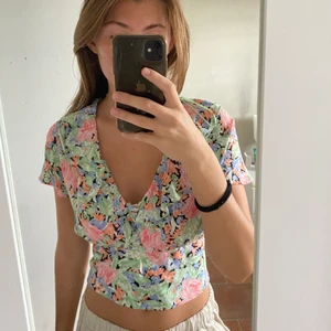 Blommig topp - Blommig kortärmad topp från Zara! Toppen är inte croppad men lite kortare än vanligt. Nedtill finns en lös resår som gör att den sätter sig fint runt midjan. Den är aldrig använd förutom i dessa bilder. Den är i storlek S. Köparen står för frakten🥰