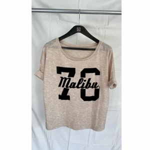 Beige topp - Beige topp ”Malibu 70”, tunnt, skönt och stickat tyg med Malibu 70 tryckt på bröstet, storlek S