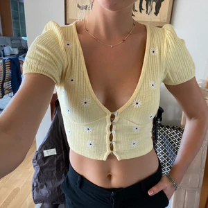 Gul croppad topp - En supersmickrande gul croppad topp från Behrska med små blommor som detaljer. Säljer då den inte kommer till användning längre tyvärr! Köpt från asos i strl small, men som nu är slutsåld. Köparen betalar själv frakten utöver toppens pris💛