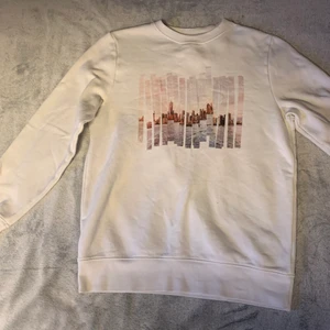 Vit sweatshirt med stadavbilning - Regular fig vit sweatshirt med stad bild i mitten. Om ni vill ha måtten på plagget så är det bara skriva