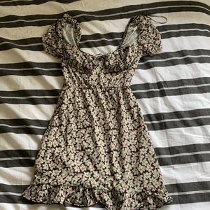 blommigklänning  - vita blommor med orange nektar o svart bakgrund, klänningen har använts ca 2 ggr o är från pull and bear 🤍