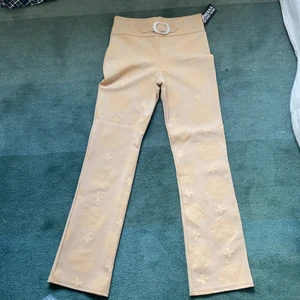 Byxor - Fina lågmidjade byxor! Har ett spänne av plast men ser lite ut som pärlemor. Helt oanvända, i superfint skick!! <3 Andra bilden är lite suddig, men ville visa hur de sitter på, mer detaljerade bilder om du bläddrar!