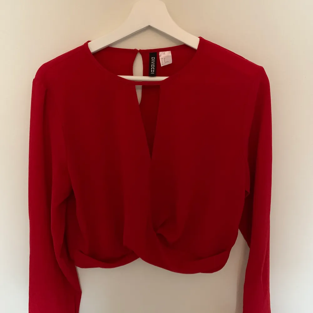 En kort röd tröja från HM, endast använd en gång. Lagom tunnt material, skulle nog klassa det år blus hållet. Lite kortare tröja som inte längre finns i butik💫 Vid intresse skriv gärna, köparen står för fraktkostnaden💖. Blusar.