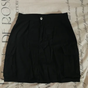 Kjol - Svart kjol i cargomodell, storlek s/36. Fickor på båda sidor. 