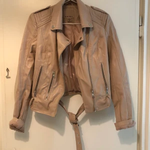 Smutsrosa skinnjacka - Från new yorker. Ena grejen är trasig där skärpet ska in men kan lagas enkelt. Fejk skinn. 