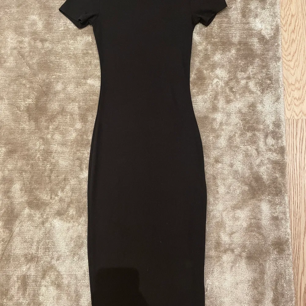 En svart figursydd klänning från H&M i storlek XS, klänning slutar vid knäna.. Klänningar.