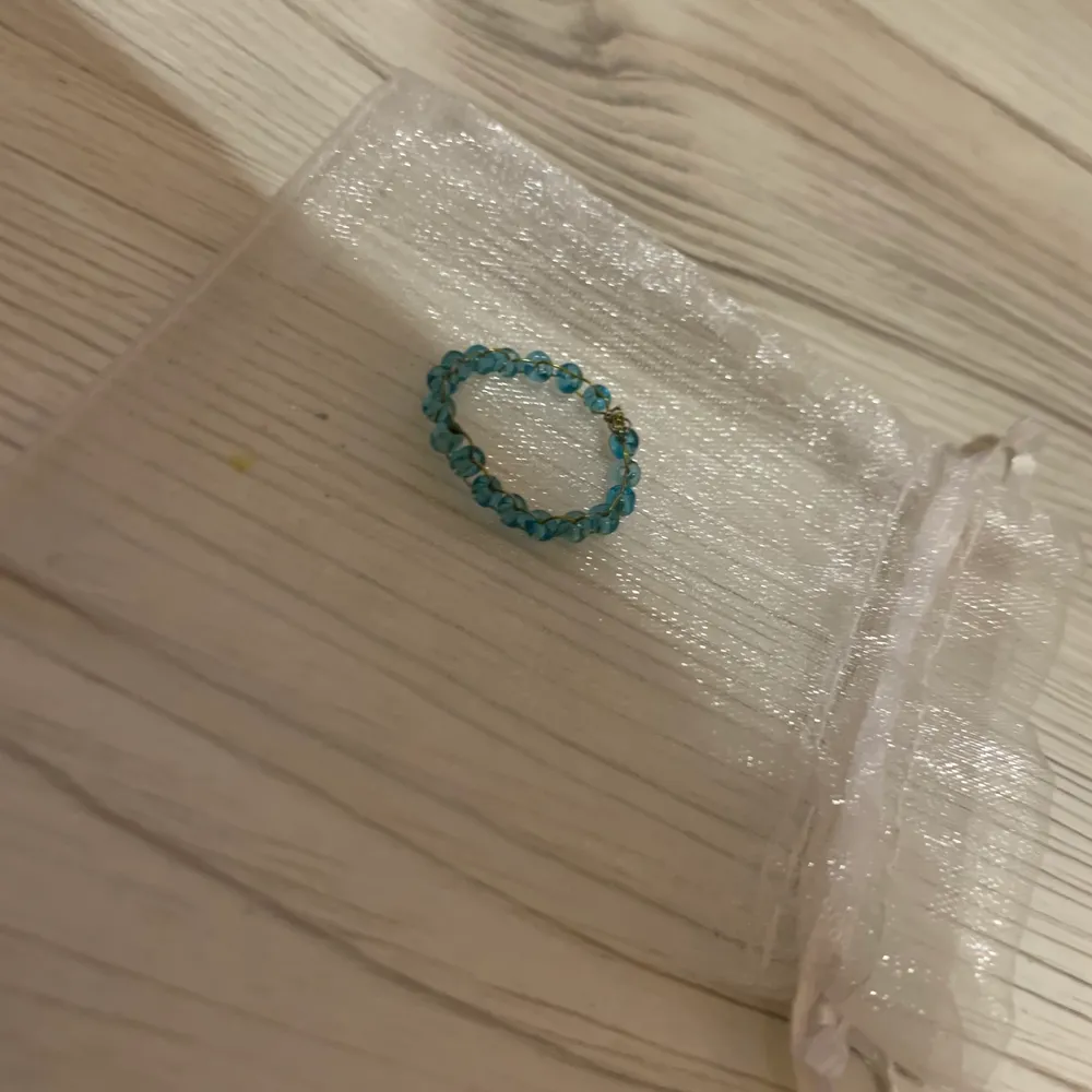 En blå ring med fina små pärlor . Accessoarer.