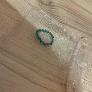 En blå ring med fina små pärlor 
