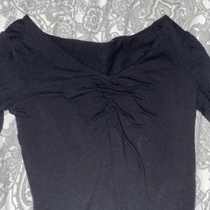 Croppad långärmad - En svart långärmad som är croppad med en detalj i mitten 