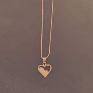 Halsband av äkta silver med ädelstenar som detaljer på hjärtat.