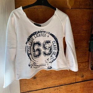 Miss Ewing Cropped Sweatshirt S/M - Vit sweatshirt med blått tryck. Storlek S/M. Ärm 3/4. Mått: ärmhåla till ärmhåla: 2x47 cm, ärmhåla till nederkant 27 cm, ärm från ärmhåla 34 cm. Råa kanter. Fint skick. Frakt 📦 66 kr. 