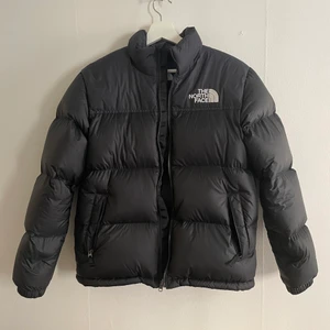 Jacka The North Face - 1996 Retro Nuptse - Säljer en svart jacka från The North Face - 1996 Retro Nuptse. Juniorstorlek XL. I mycket fint skick, använd bara en handfull gånger. 