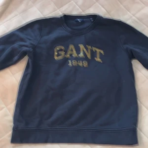 Gant sweatshirt size M - Tröjan är 2 år gammal och har använts många gånger. Den har inga fläckar på tröjan. Tröjan är mörk blå med guld logga.