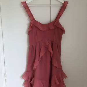 Rosa klänning från Linn Ahlborgs kollektion med NAKD. Klänningen har volanger och dragekedja på sidan, använd ett fåtal gånger. Sista bilden visar färgen bäst. Storlek 36 - Frakt tillkommer💕☺️