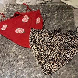 Croppad topp linne - Leopard mönster och röd med rosor croppad linne med knyt där bak. I strl XS-M knappt använd. 100 för båda eller 50 kr/st.