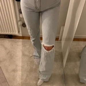 Ljusa jeans - Ljusblå jeans med hög midja och hål på ena knät. Jag är 165 cm och de är lite långa på mig. Storlek 32 men stora i storleken och sitter mer som en 34a.