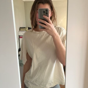 Cheap Monday t-shirt - Krämvit t-shirt från Cheap Monday! Tröjan har en slit vid båda armarna, vilket ger den mer karaktär😍 Den är i storlek XS, men är oversized så passar även S/M. Använd runt 5 gånger. Köparen står för frakten!