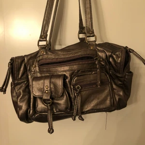 Väska  - Skit snygg väska med många fack finns lite slitningar på axelbanden 