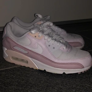 Nike Air Max 90 stl 39 - Vita och rosa Nike sneakers, ganska små i storlek. Inköpta i våras för 1400kr och använda Max 5 gånger. Finns en missfärgning på undersidan sulorna men annars i fint skick💕