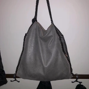 Stella McCartney ljusgrå mellan  - 1700kr snabb affär. Intressekoll på min gråa älskade stella mccartney väska. Den är i jätte bra skick!! Kan tyvärr inte garantera äktahet då jag köpte den på plick (därav priset), men allt tyder på att den är äkta! Jag postar med spårbar frakt ❤️👌🏼 (första bilden är lånad och den har inte en sån plånbok, då det är en modell mindre) 