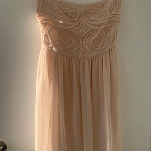 Sommarklänning i nudefärg - Mycket fin sommarklänning perfekt för en fest eller picknik. Tunk och skönt material. Klänningen är axelbandslös. Storlek XS
