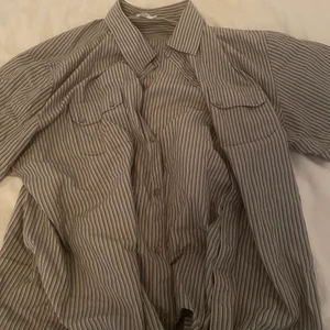 Skjorta - Grå randig skjorta i oversize modell från Calvin Klein. Storlek xxl, i bra skick! Frakt tillkommer. Bara att höra av sig vid frågor och funderingar!:))