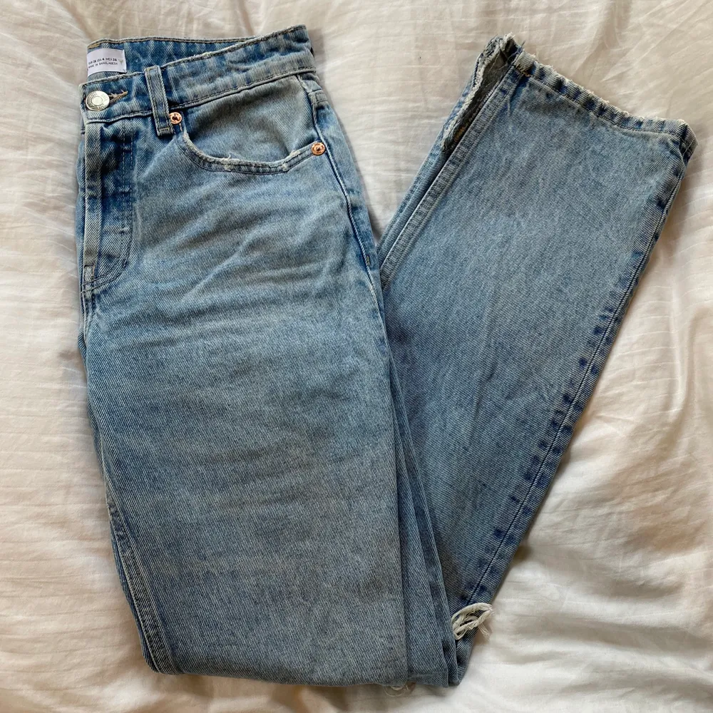 Ljusblå raka jeans från Zara med hål på knäna. Jag har klippt till en slits på båda benen då jag tyckte att de var lite långa för mig och tycker att de faller snyggare över skorna med slitsen. Dessa är använda ett fåtal gånger men är verkligen i bra skick! Jag är 1,65 och de är som sagt lite långa men tycker det är snyggt. 💗. Jeans & Byxor.