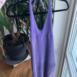 Lila glittrig klänning från 80talet - XS superfin klänning mamma hade på 80-talet, sparsamt använd. Halvt öppen rygg snörning bakom nacken men skulle gå att sy om enkelt så de blir axelband. Säljer för att den inte passar någon i hushållet. Betalning via swish, kan mötas i centrala/södra Stockholm eller frakt på 48kr