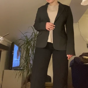 Mörkgrå kavaj strl M - Mörkgrå kavaj från H&M med lite ränder. Egentligen storlek 40/L men sitter ungefär som M. Ett näst intill nyskick och väldigt stilig och bra kvalite. 