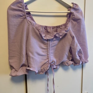 Sommar tröja  - En superfin lila tröja med lätt puffiga axlar. Använd 1 gång. 