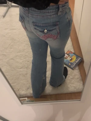Jeans med röd rosa detaljer - Jag säljer dessa jeans eftersom dom sitter för tight på mig. Dom har inte används än och är i perfekt skick. Dom går att justera i midjan och jag är cirka 169 så dom sitter bra i längden❤️