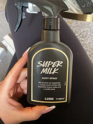 Lush Super Milk Body Spray 200ml 450kr nypris, endast använd ett fåtal gånger - Super Milk Body Spray från Lush med fräscha toner av citron och en hint av vanilj. Flaskan är svart med vit och gul text, och rymmer 200 ml. Perfekt för dig som vill dofta gott hela dagen.