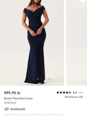 Marinblå balklänning - Helt ny med lappen kvar. Elegant marinblå långklänning från Goddiva med bardot-ringning och figurnära passform. Klänningen har omlottdetaljer upptill och är axelbandslös, vilket ger en stilren och sofistikerad look. Perfekt för speciella tillfällen.