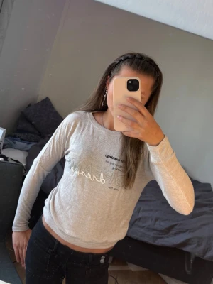 Beige långärmad topp med text - Beige långärmad topp från Lace by Lindex med tryckt text på bröstet. Toppen har rund halsringning och en mjuk, lätt stretchig känsla. Perfekt för en avslappnad och trendig look.
