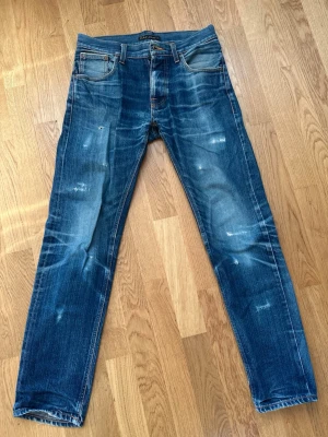 Nudie jeans - Tja! Säljer dessa feta nudie jeans i storlek 29/32. Skick 5/10 bra skick förutom hål i fickor. OBS! Nudie erbjuder gratis lagningar så detta kan lätt fixas. Modell: Steady Eddie, straight/slim fit. Sitter straight ish på mig är ca 180, 70kg. PM vid frågor eller funderingar. /TA