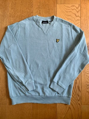 Ljusblå stickad tröja Lyle & Scott - Fin tröja perfekt för sommaren .