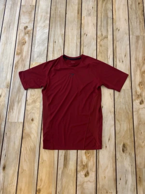 Vinröd compression från Gymshark - Snygg vinröd compression från Gymshark med korta ärmar och rund hals. Tillverkad i ett lätt och snabbtorkande funktionsmaterial som passar perfekt till gymmet eller löprundan. Diskret logga på bröstet i svart. Använd 1 gång 