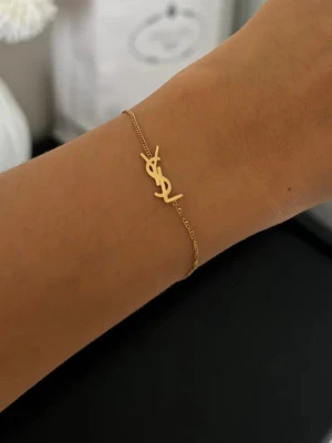 Guldfärgat armband från Saint Laurent - Ysl armband, helt ny, ej äkta!! Står saint Laurent - Paris på.