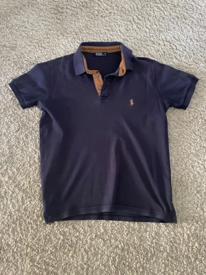Mörkblå pikétröja från Polo Ralph Lauren - Klassisk mörkblå pikétröja från Polo Ralph Lauren. Storlek M men passar S bättre. Priset går att diskutera vid snabb affär.
