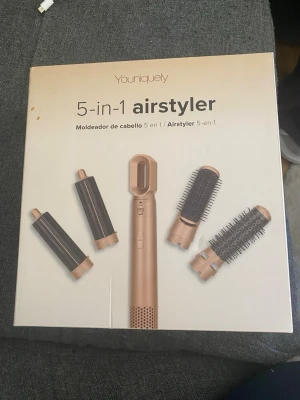 Youniquely 5-in-1 airstyler hårverktyg - Multifunktionellt hårverktyg i roséguld med fem utbytbara tillbehör för styling, lockning och borstning. Passar för att skapa olika frisyrer och volym. Tillverkad i plast och metall med modern design.