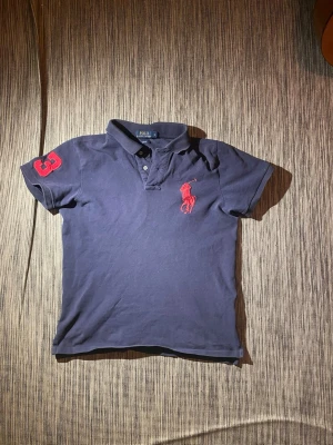 Marinblå pikétröja Polo Ralph Lauren -  marinblå pikétröja från polo Ralph lauren. Står L men sitter som S möjligtvis M