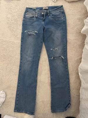 Blå slitna jeans från LTB - Säljer ett par blå jeans från LTB, modell VALERIE. Strl 27/32. Klippt hålen själv 